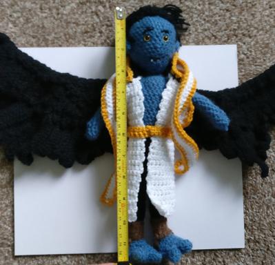 The doll, with measuring tape showing the height