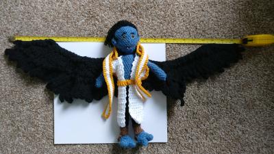 The doll, with measuring tape showing the width