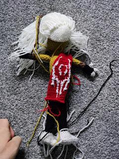 Back view of the in-progress doll, showing the cape