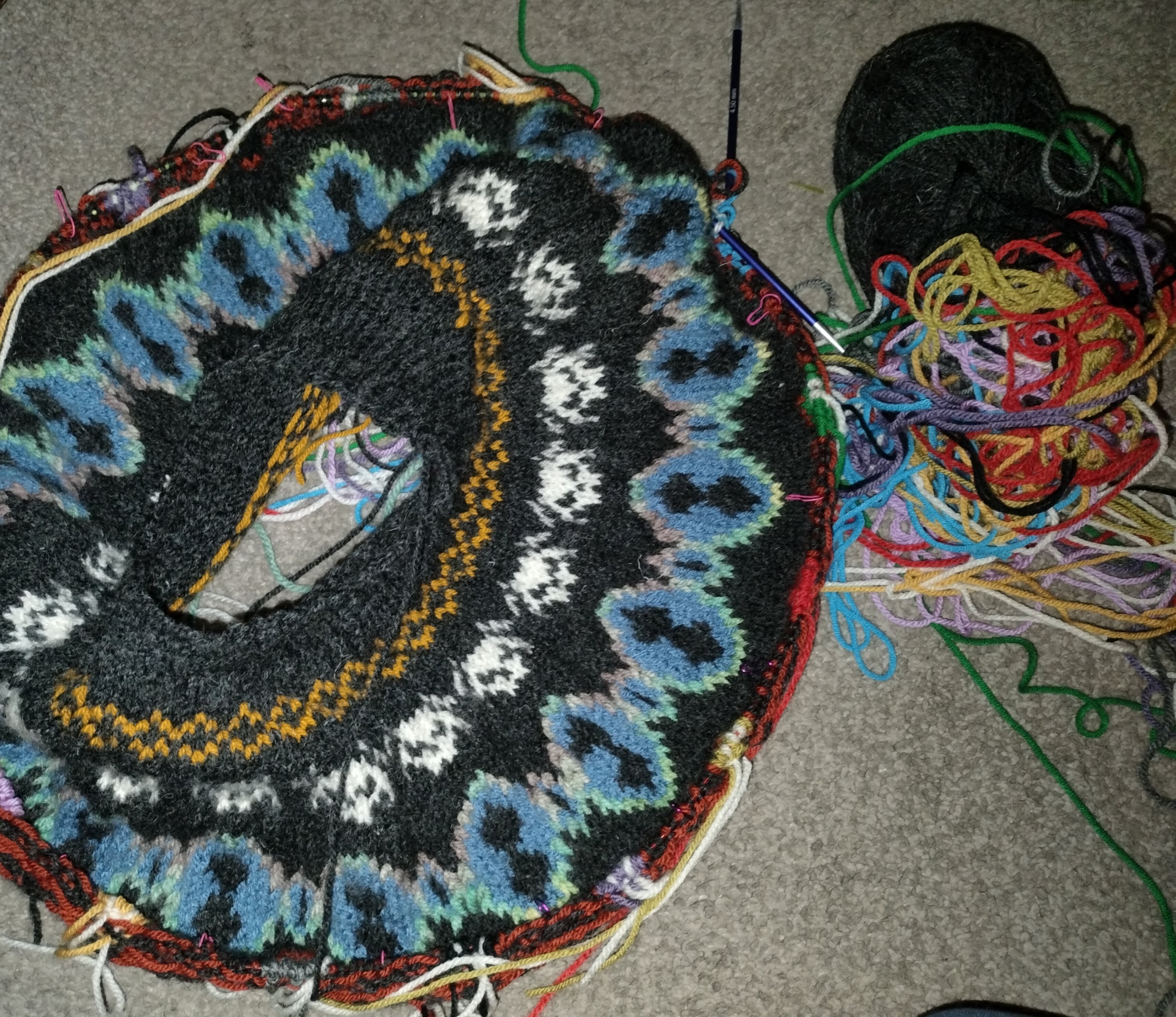 The yoke with the Pillar symbols in progress, and the yarn spaghetti next to it